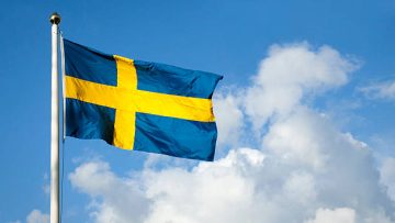 Swedish flag blowing in the wind on a sunny day.